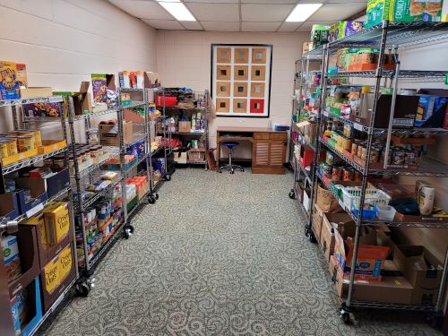beige room lined with metal shelving containing cases of food